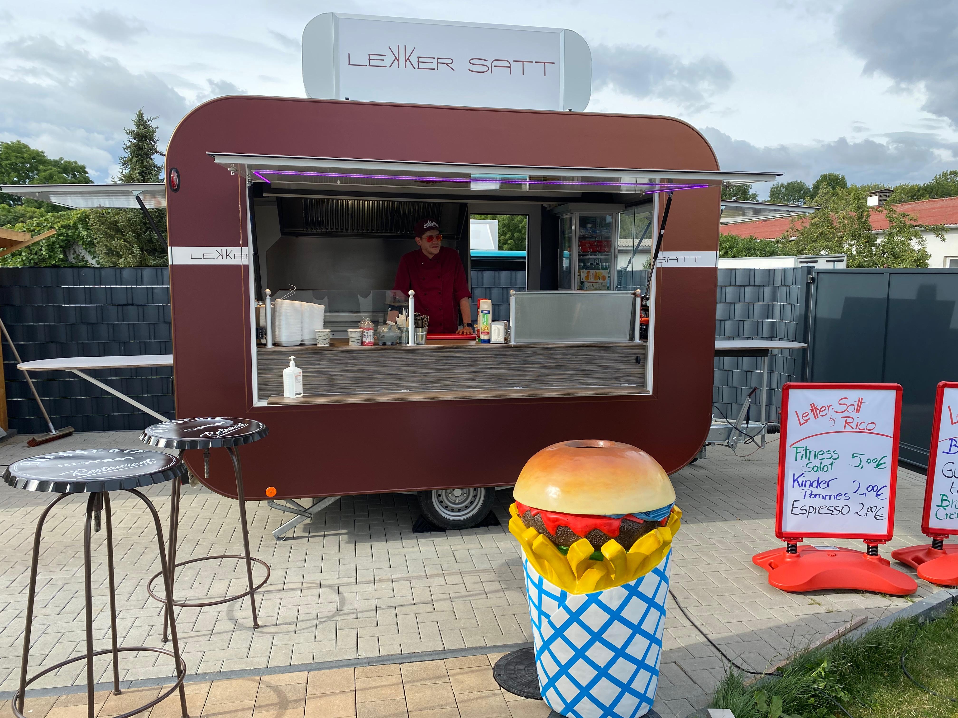 Lekker Satt Food Trailer mit Frontansicht und Deko